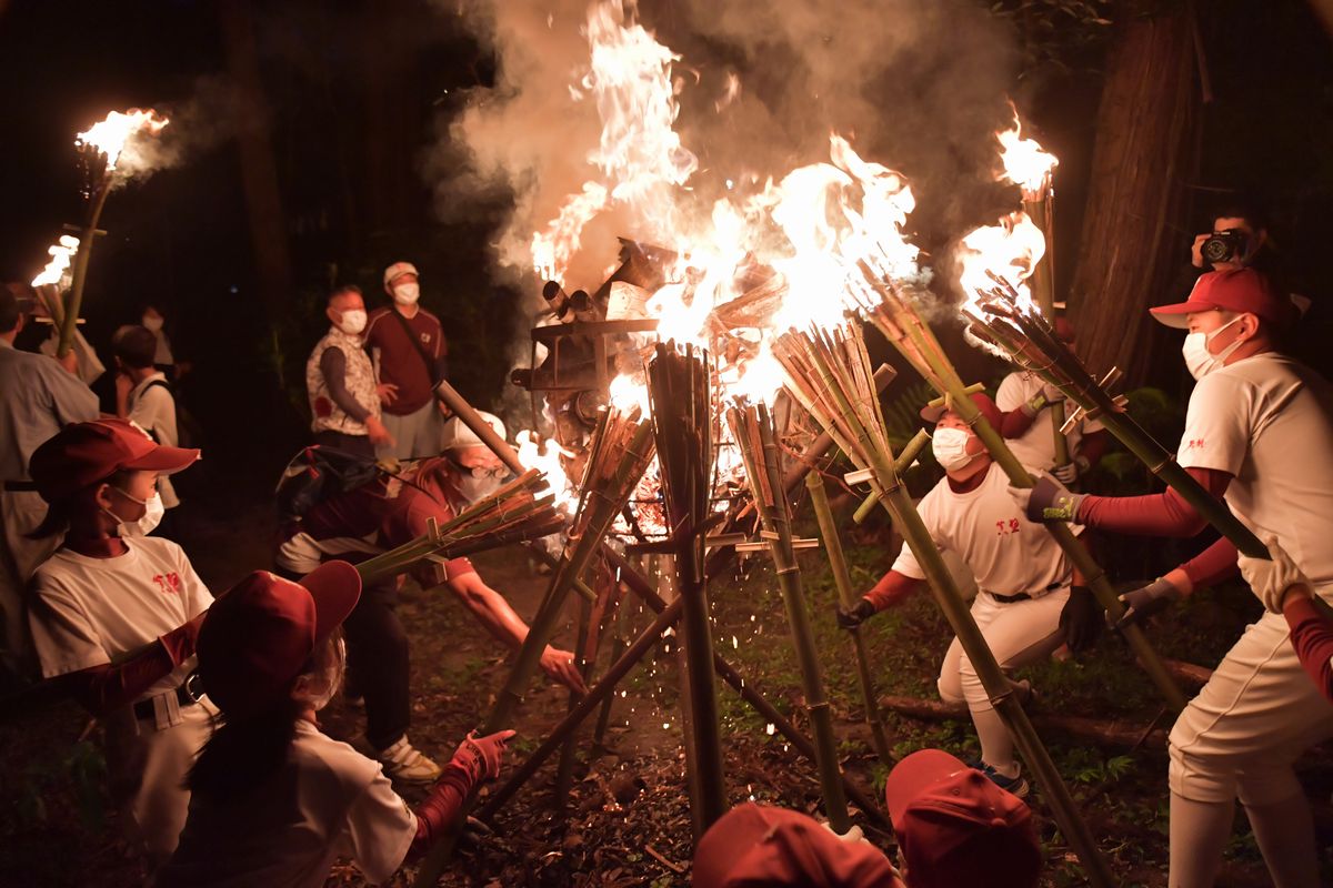 たいまつに火を移す、「かったて祭り」の参加者ら＝2021年8月31日午後6時半ごろ、桜川市真壁町山尾