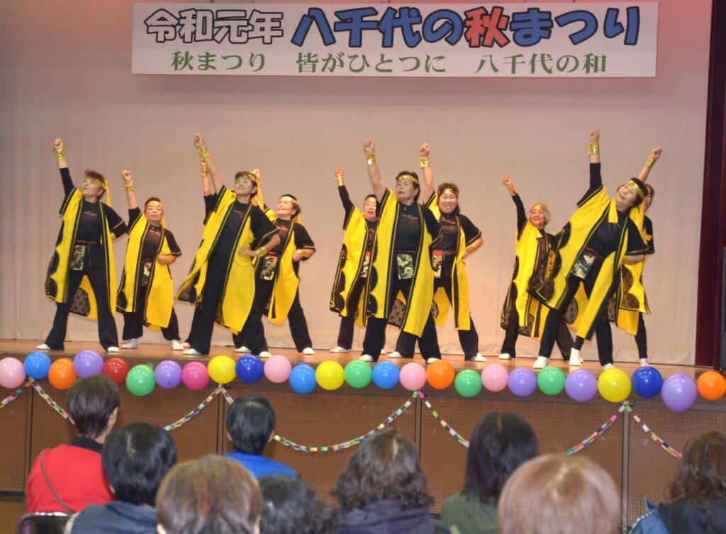 きらびやかな装いで踊る「八千代ソーラン愛好会　絆」のメンバーら＝2019年11月24日、八千代町菅谷