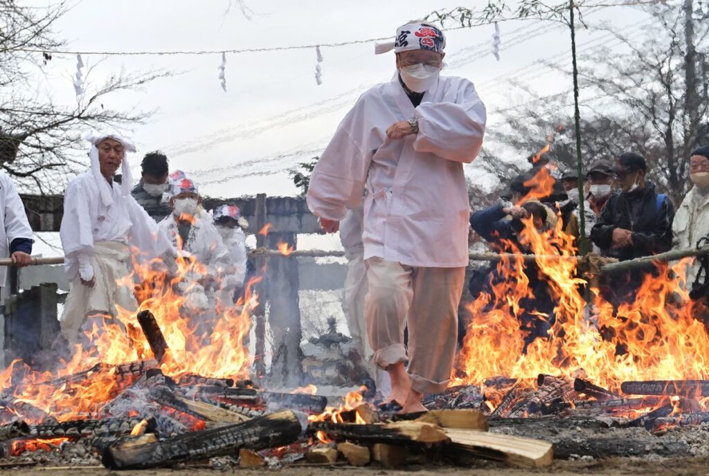 加波山三枝祇神社本宮の火渉祭で火の道を歩く参加者＝2022年12月22日午後、桜川市真壁町長岡