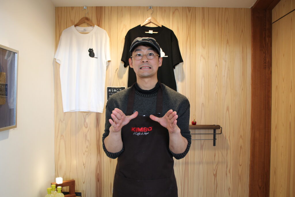 ろくろを回すポーズをするオーナーの大木さん。ギターが趣味で希望者にはバースデーソングのプレゼントも