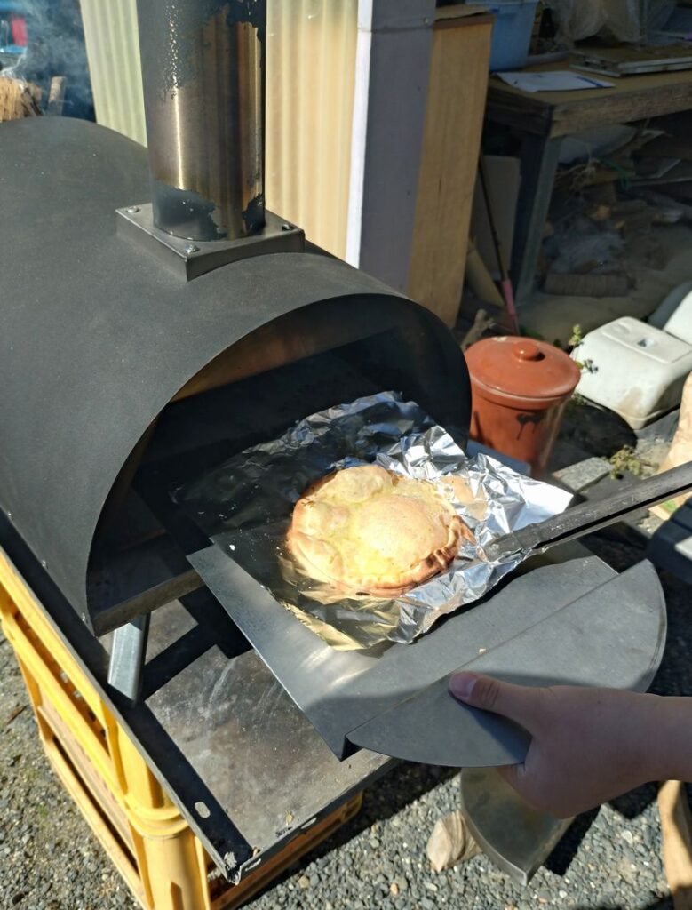 焼き上がったピザを窯から取り出します