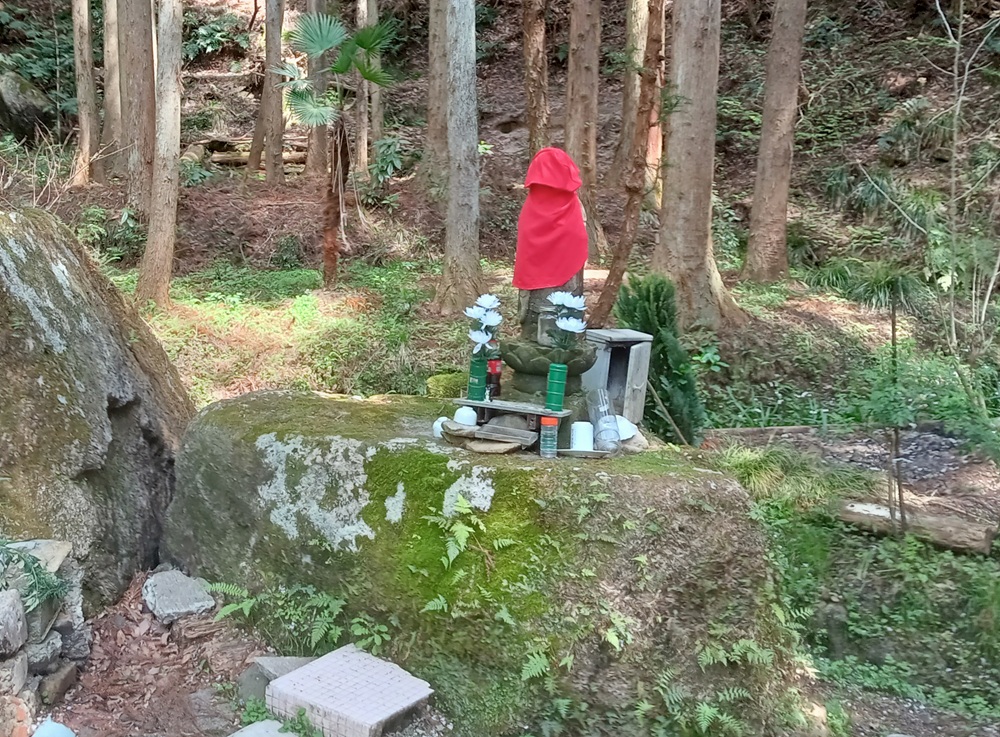 幽霊林道・湯袋峠手前にある石仏。赤い布に覆われてお顔が見えません