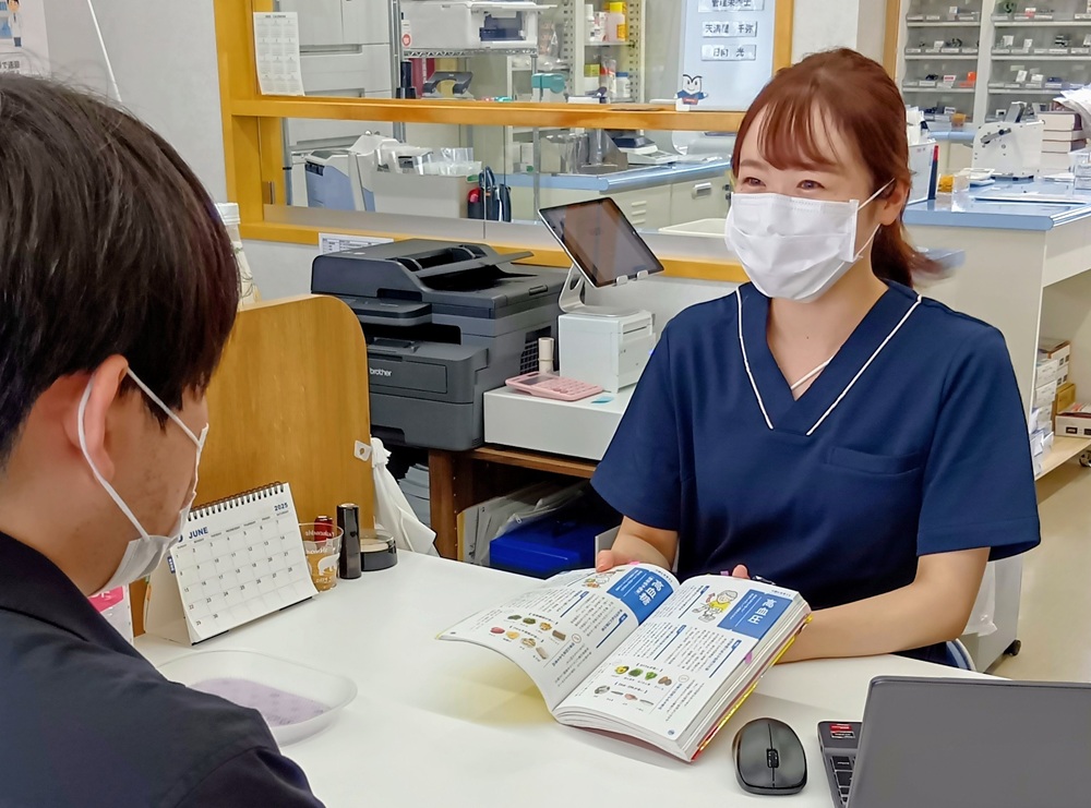 専門書などを使い丁寧に説明する日向さん