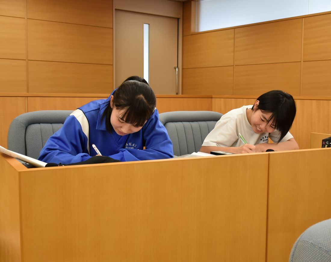開放された境町議会の議場で、議員席に座って勉強する中学生ら＝2019年7月