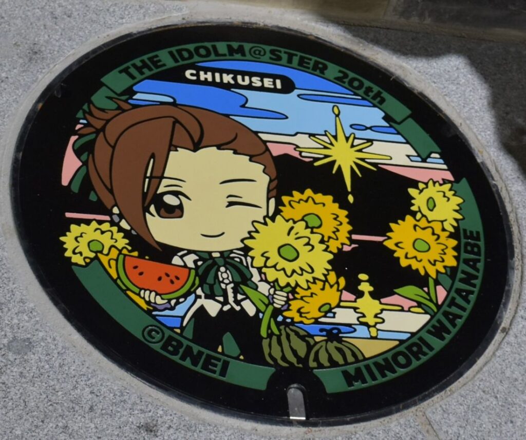 「渡辺みのり」と筑西市の名物などがデザインされたマンホールふた