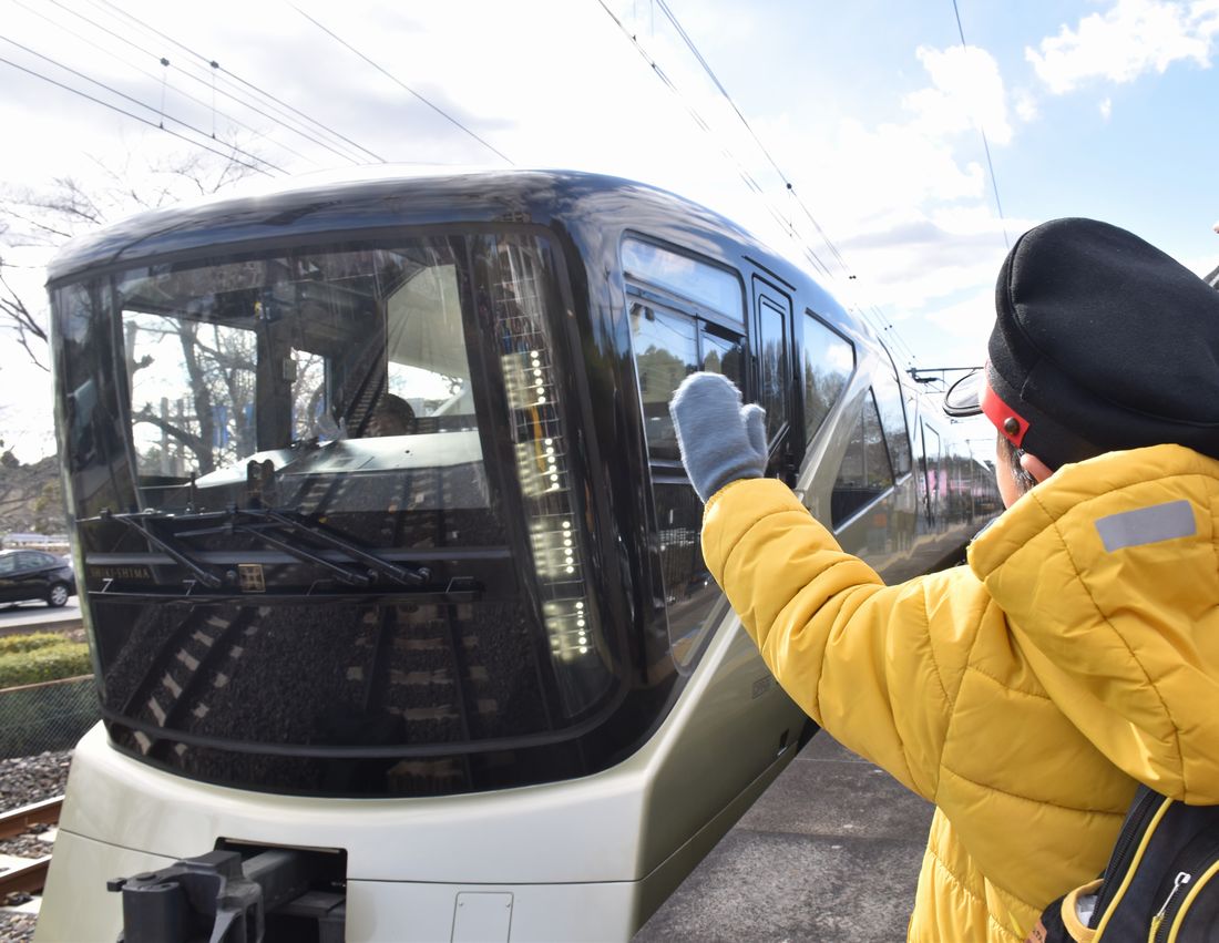 偕楽園駅に到着したＪＲ東日本のクルーズトレイン「TRAIN SUITE　四季島」に手を振る子ども＝2024年3月2日、水戸市常磐町