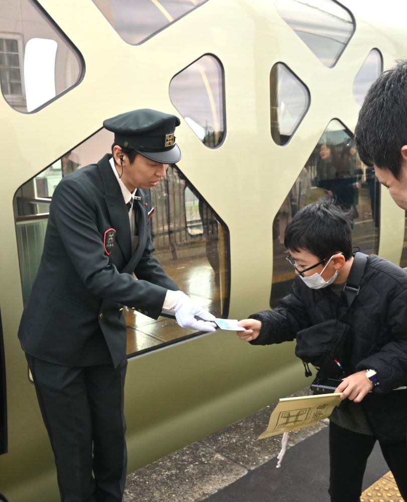 四季島の車掌から名刺を手渡される子ども＝桜川市犬田