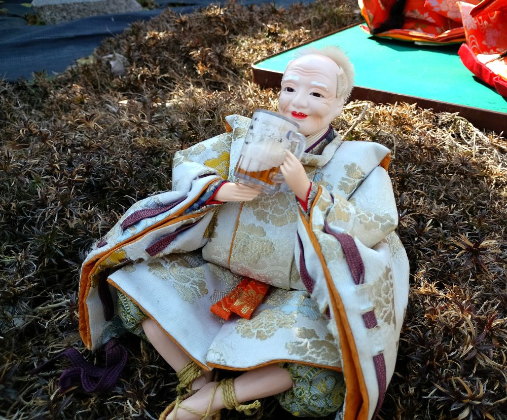 ジョッキでビールを飲むひな人形