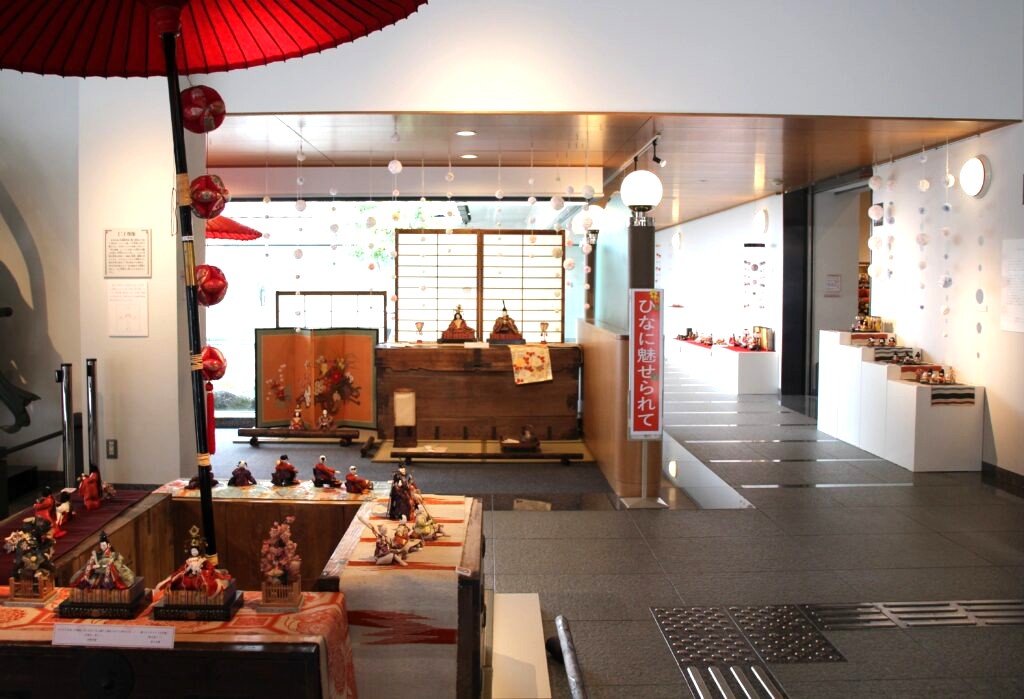 中庭から指し込む光に包まれたエントランスホールでひな人形がお出迎え