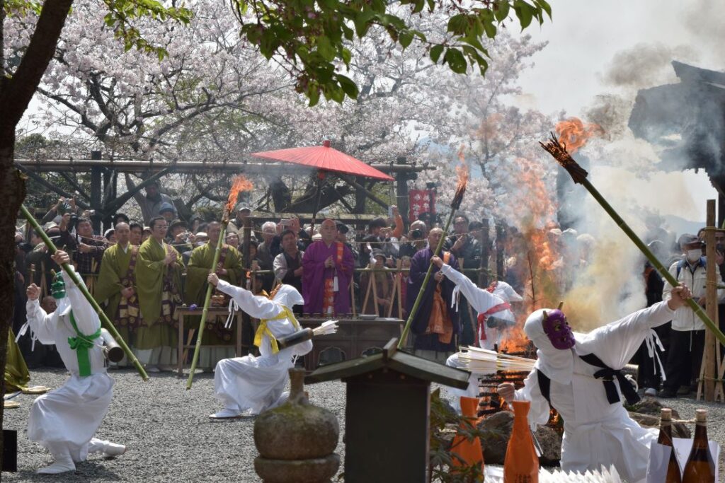護摩の炎のそばで踊る鬼たち=桜川市本木