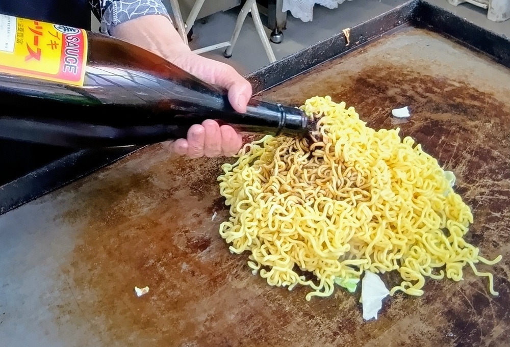 山盛りの麺に特製ソースがかけられます