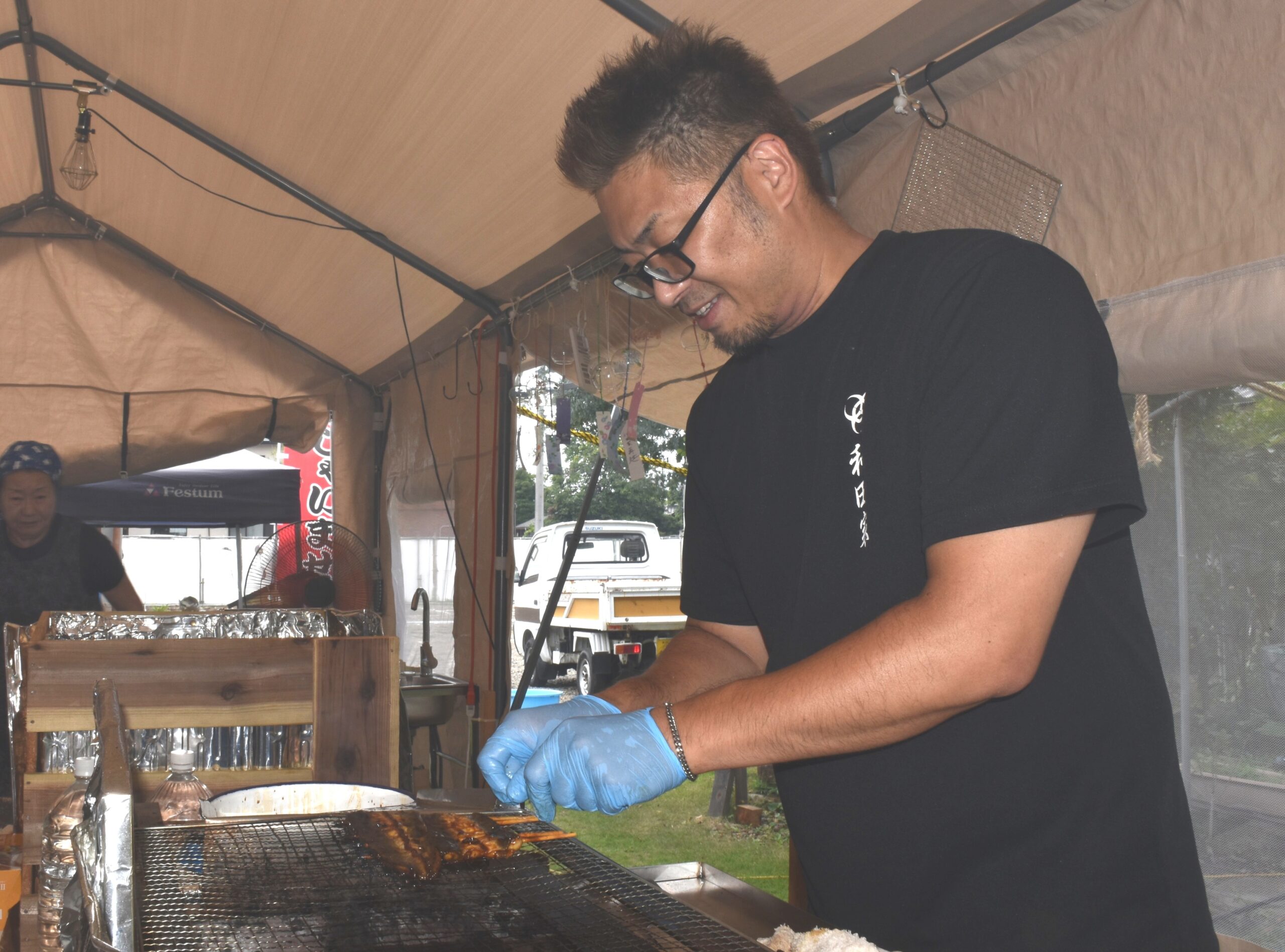 仮設テントでウナギを焼く６代目店主の大和田晶吾さん＝古河市中央町